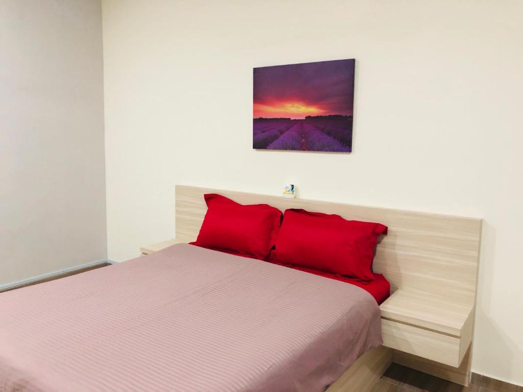 a bedroom with a bed with red pillows at Seri Manjung HomeStay @Spacious Family Home in Seri Manjung