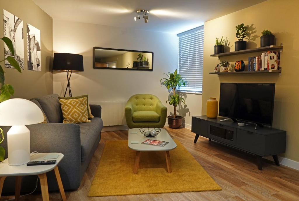 a living room with a couch and a television at Modern One Bedroom Apartment in Cardiff Bay in Cardiff