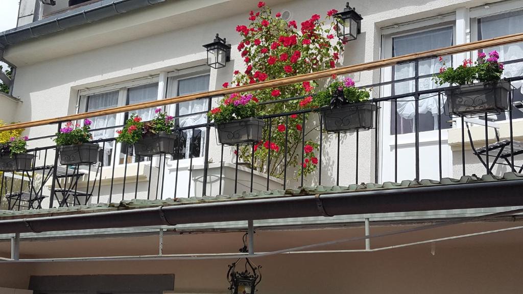 a balcony with potted flowers on a building at Les Iris Chambres d’hôte in Niedermorschwihr