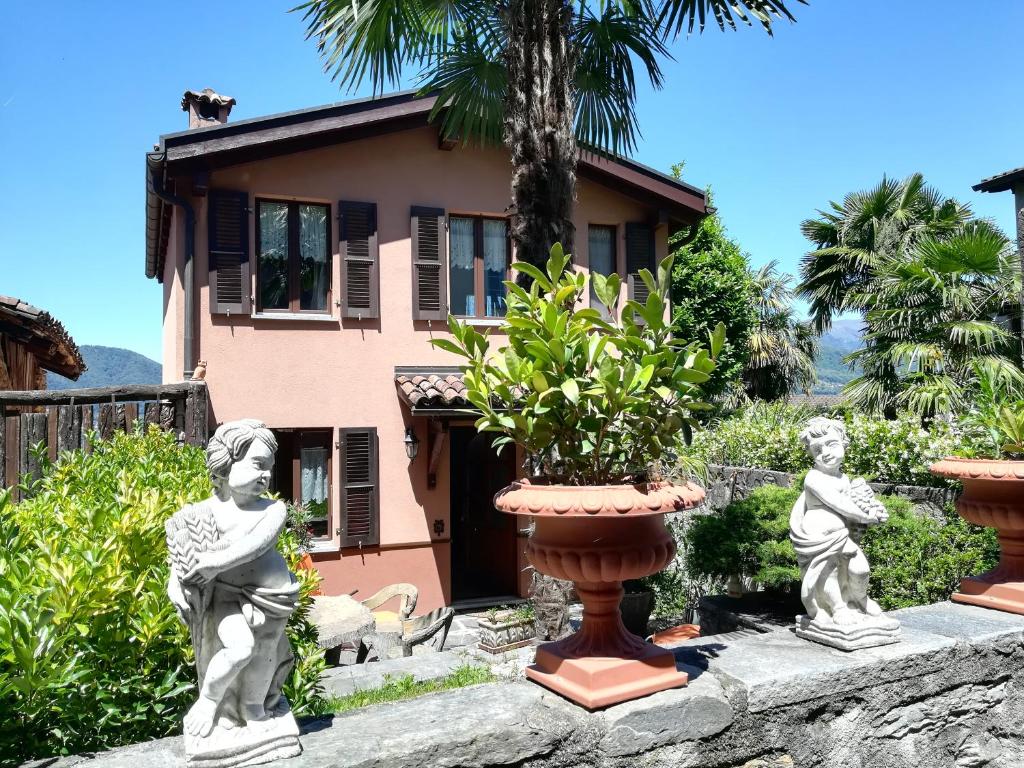two statues of children in front of a house at Casa Olivo in Montagnola