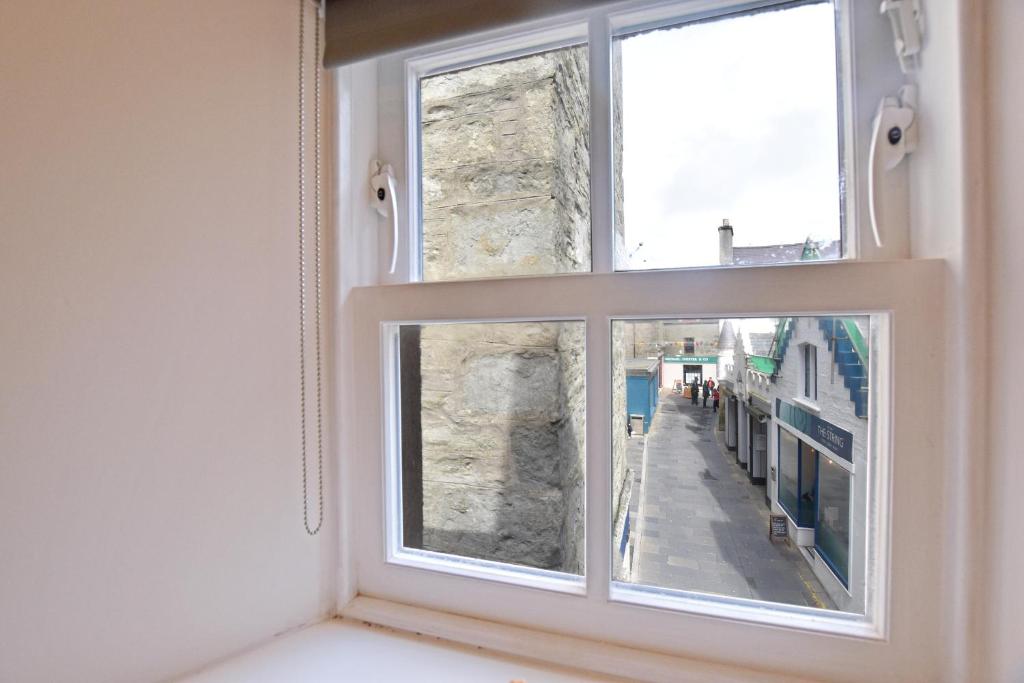 a window with a view of a street at Modern Commercial Street Maisonette in Lerwick