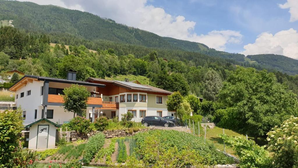 a house with a car parked in front of a mountain at Appartementhaus Zraunig in Flattach