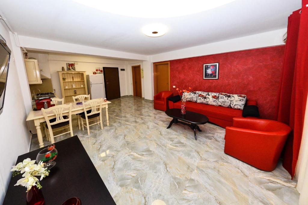 sala de estar con sofá rojo y mesa en Apartament Florin, en Mamaia