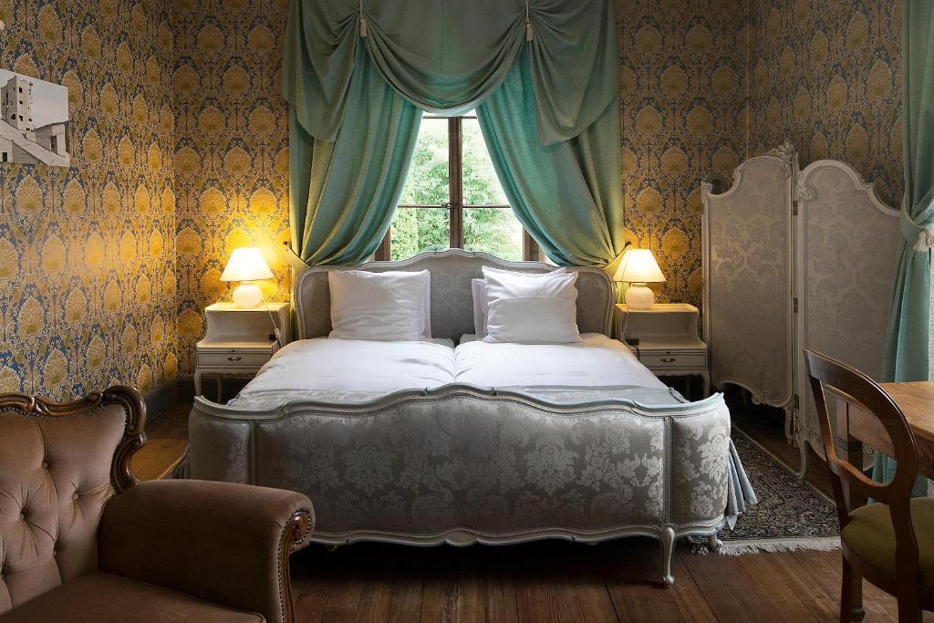 a bedroom with a bed with a window and a chair at Au Vieux Manoir in Monthey