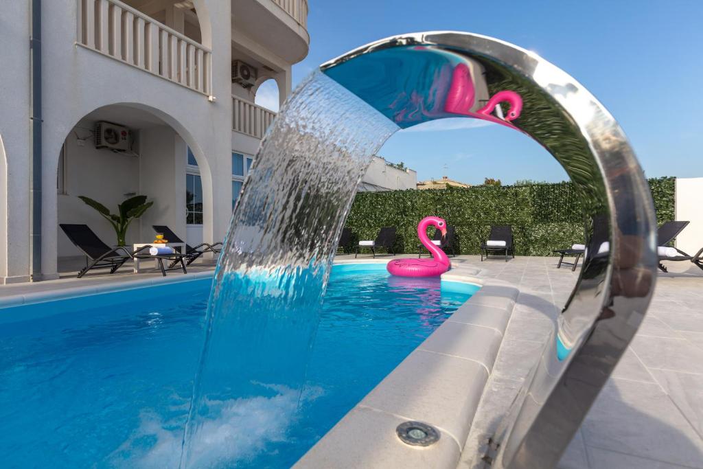 a pool with a pink flamingo in the water at Villa Anja in Split