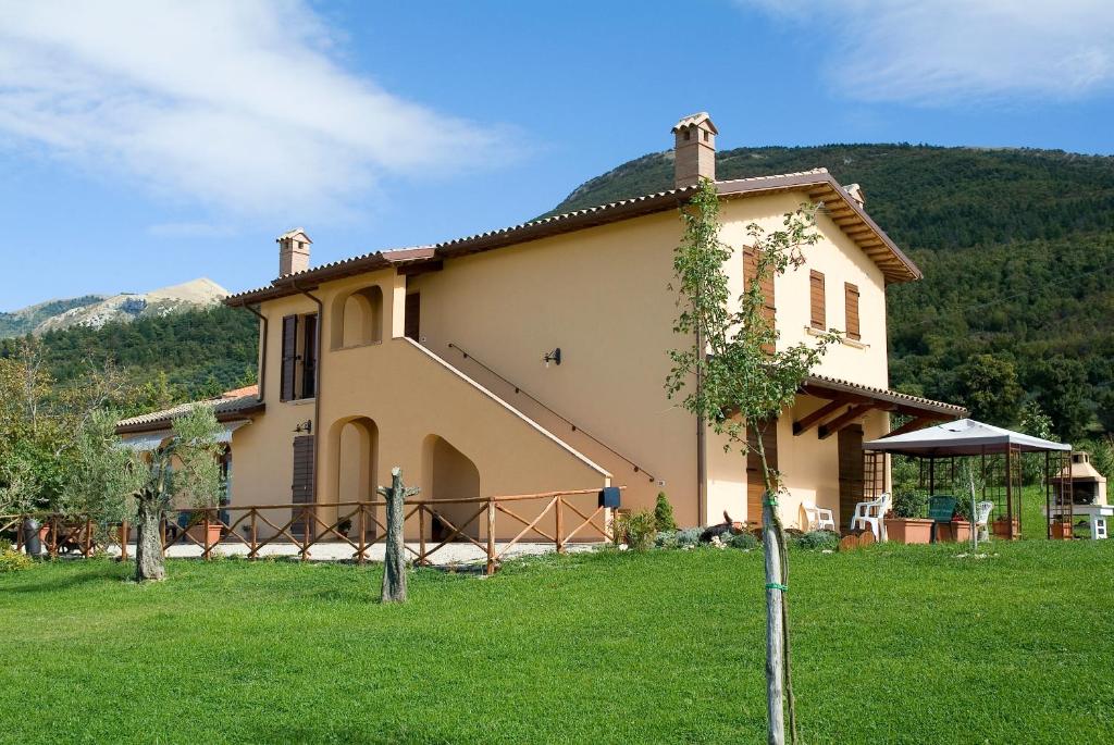 a house with a green lawn in front of it at Azienda Agrituristica Bocci in Gualdo Tadino