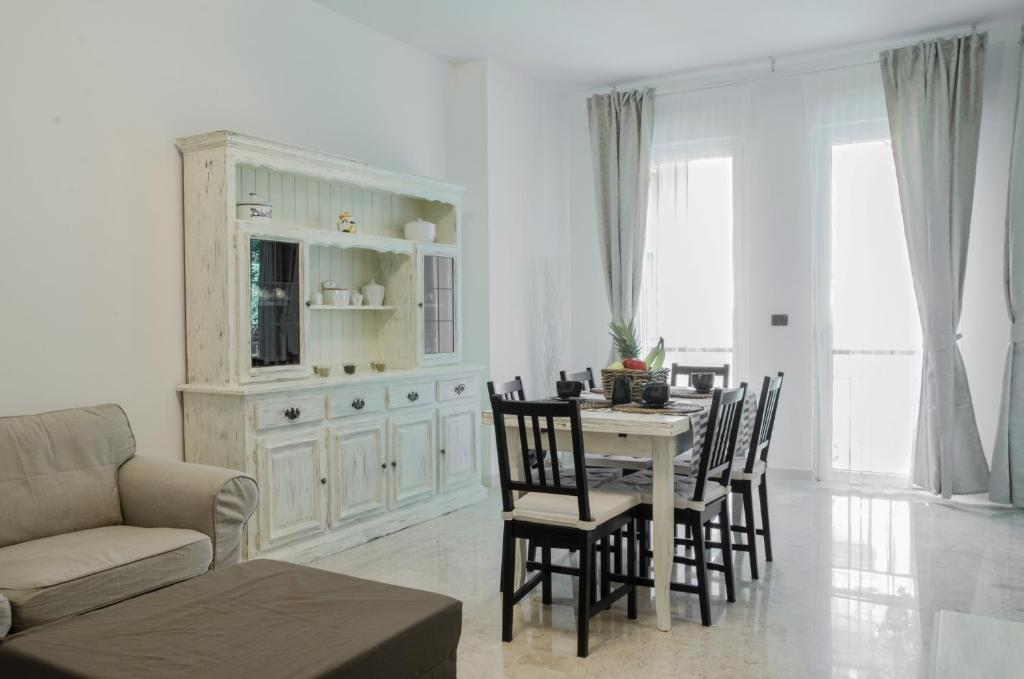 uma sala de estar branca com uma mesa e cadeiras em A casa di Anna em Lavagna