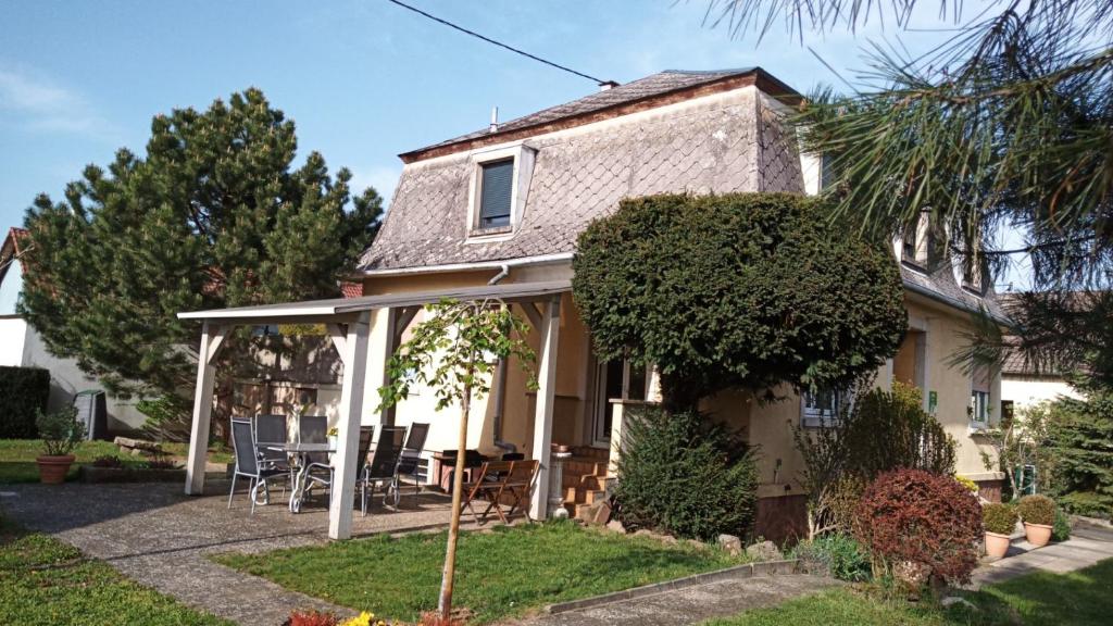 a house with a porch with a table and chairs at La Villa Mansard in Kirchheim