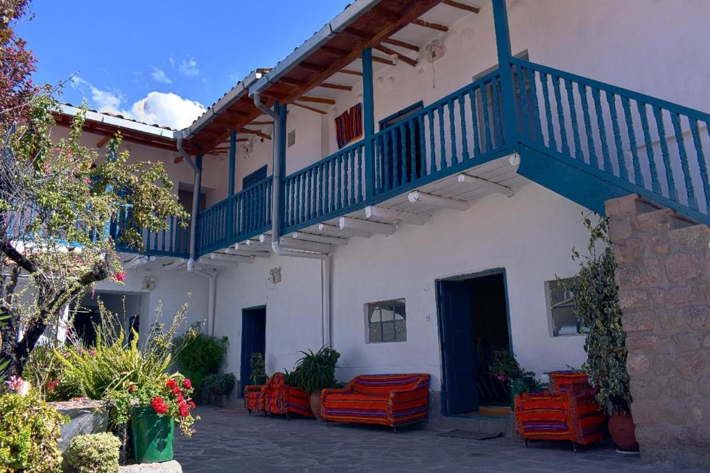een wit gebouw met een blauwe trap en oranje stoelen bij La Estacion San Pedro in Cuzco