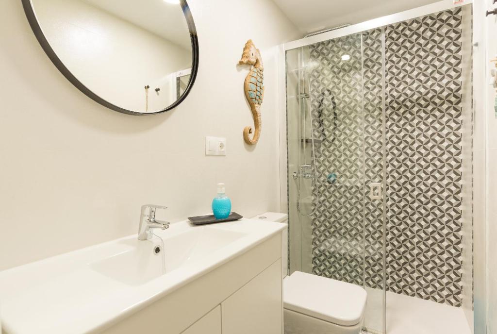 W łazience znajduje się prysznic, umywalka i lustro. w obiekcie Cozy Loft Near The Beach w mieście Torremolinos