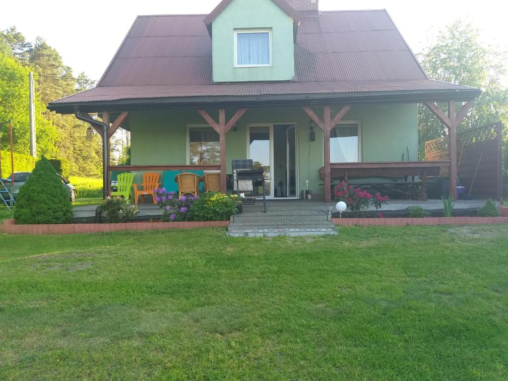 Dom Na Mazurach في Przerwanki: منزل أخضر صغير مع سقف أرجواني