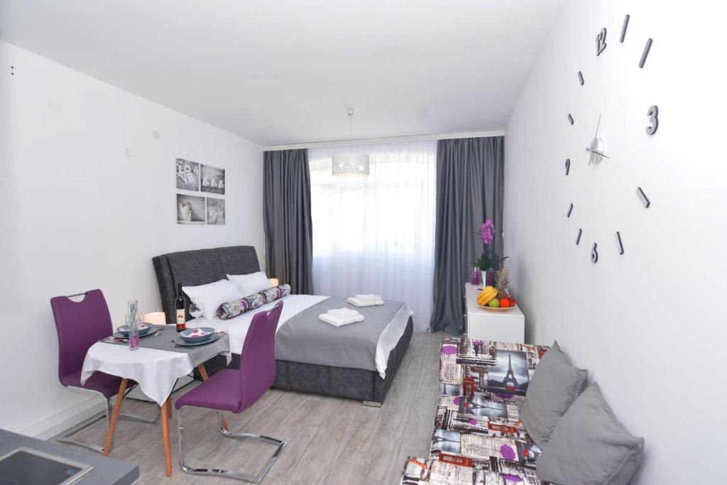 een hotelkamer met een bed en een tafel en stoelen bij Small Oasis Apartment in Tivat