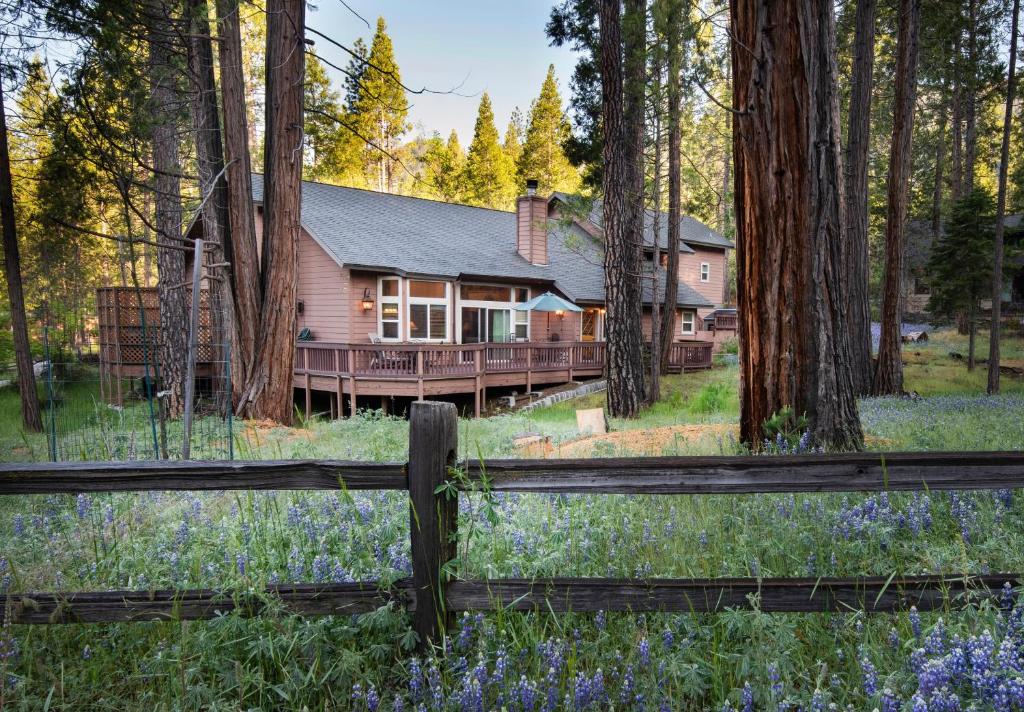 a house in the woods with a fence at 2A The Terry Cabin in North Wawona