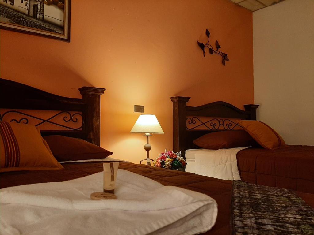 a hotel room with two beds and a table with a towel at Hotel Vista San Francisco in Antigua Guatemala