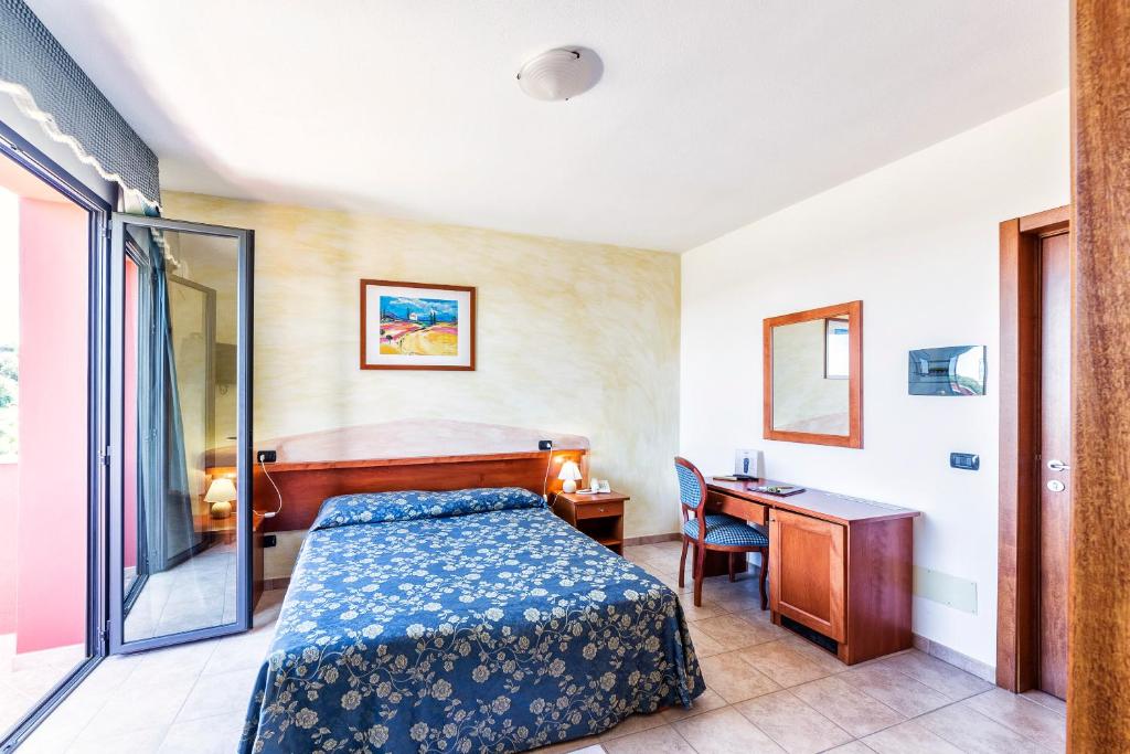 a hotel room with a bed and a desk at Hotel Il Melograno in Tempio Pausania