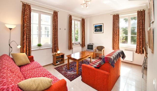 a living room with a red couch and a table at Apartament w Sercu Starówki in Gdańsk