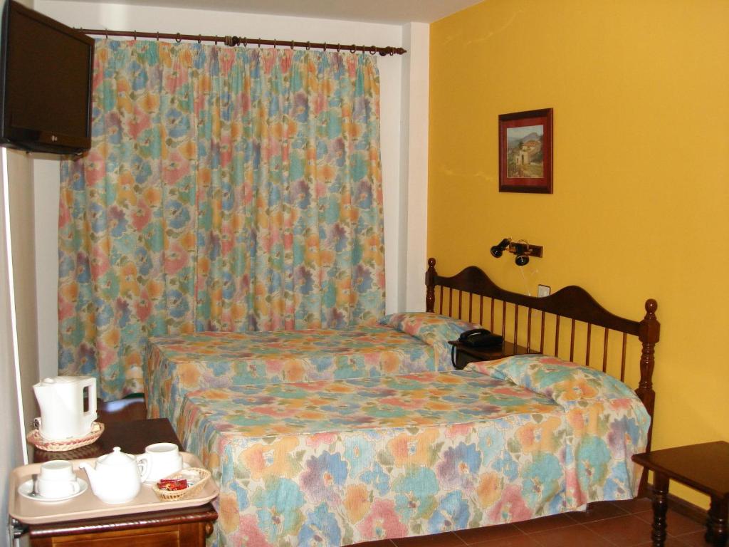 a small bedroom with a bed and a curtain at Hotel Ida Inés in Frontera