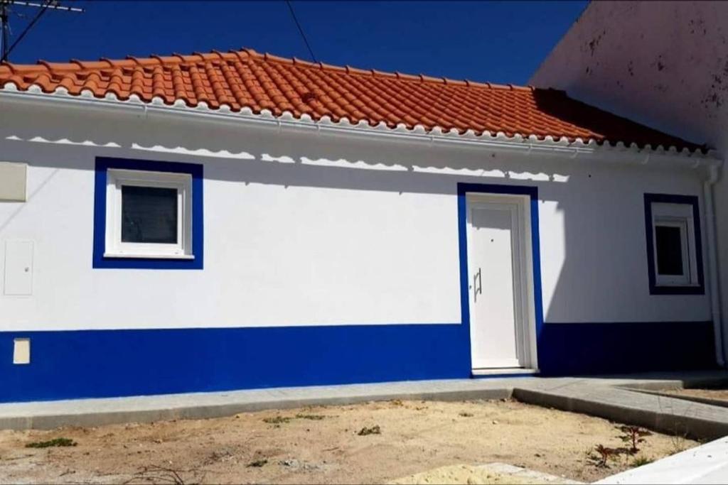 uma casa branca e azul com uma porta em Casa da Maçã em Sesimbra