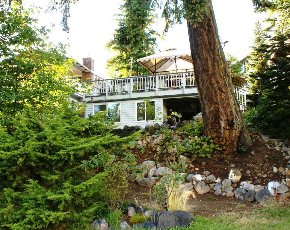 una casa con un gran árbol delante de ella en Linda's By The Lake, en Maple Valley