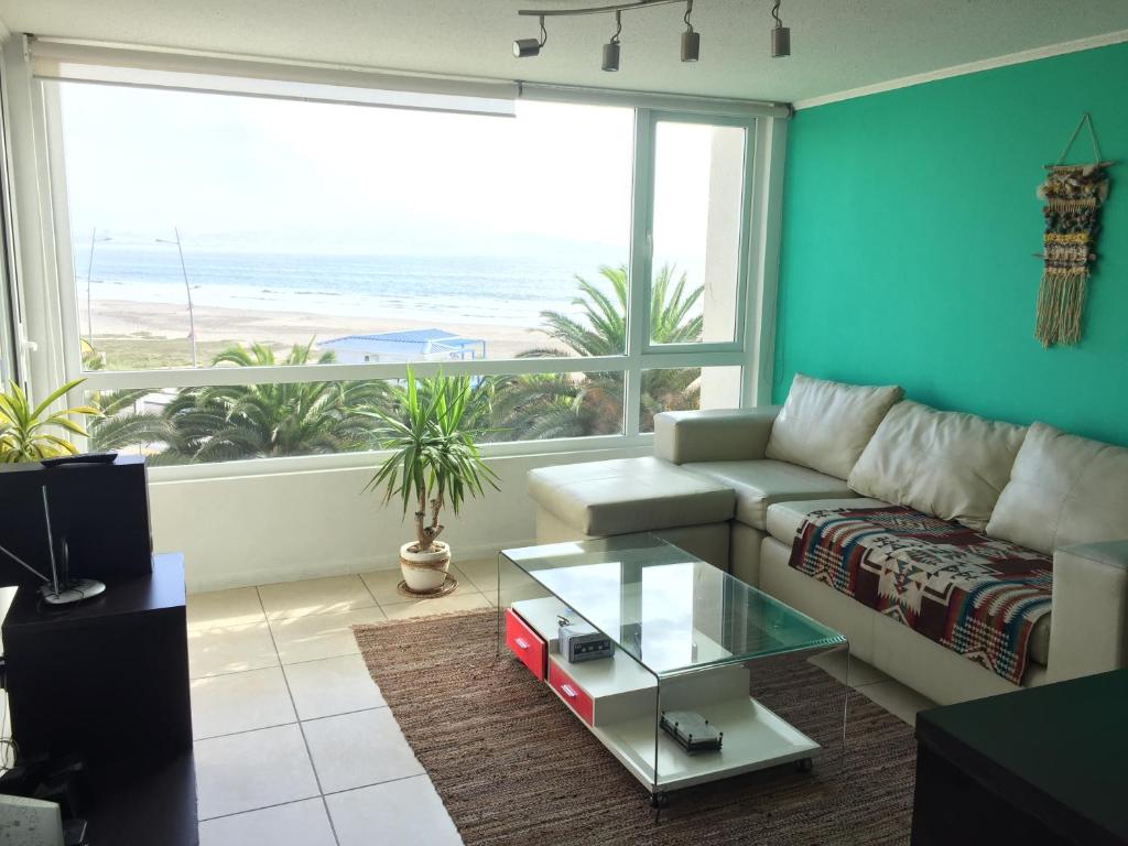sala de estar con sofá y ventana grande en Departamento Marserena frente al mar, en La Serena