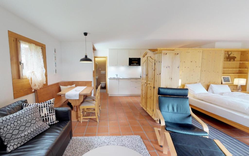 ein Wohnzimmer mit einem Sofa und einem Bett sowie eine Küche in der Unterkunft Maurus A4 in St. Moritz