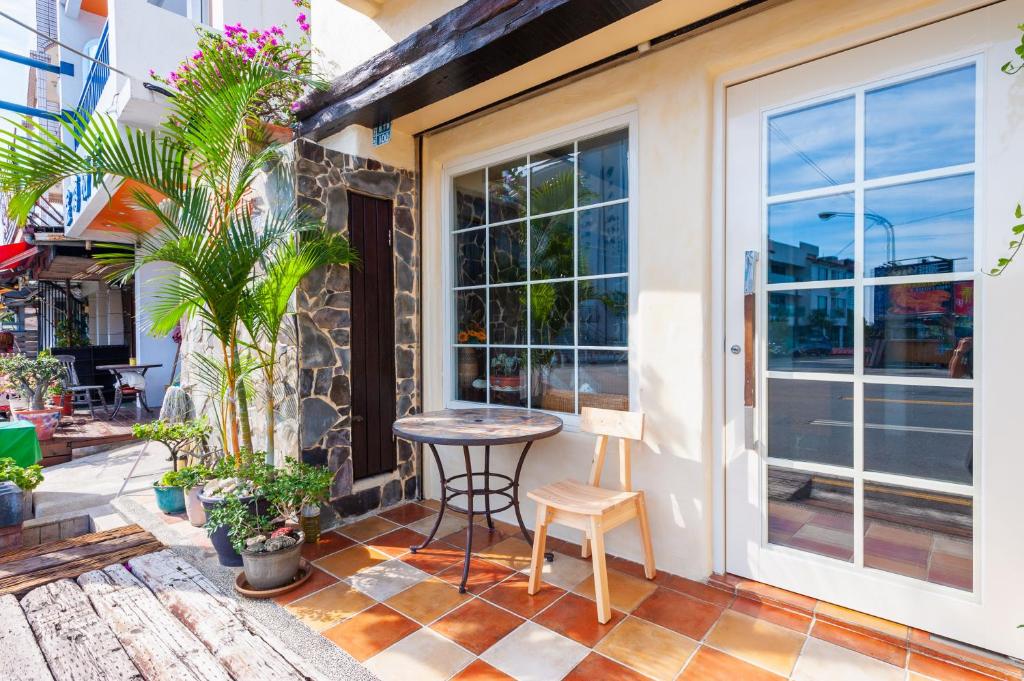 a patio with a table and chairs and a window at Mong Shan Homestay in Kenting