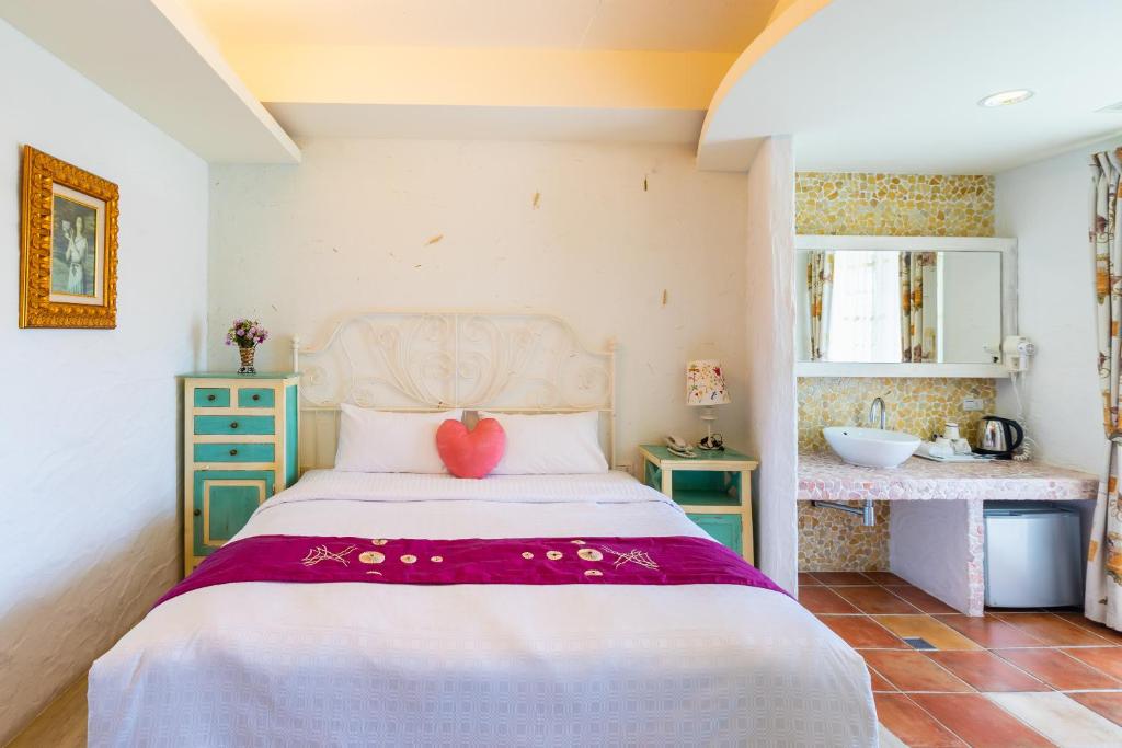 a bedroom with a bed with a pink heart on it at Mong Shan Homestay in Kenting