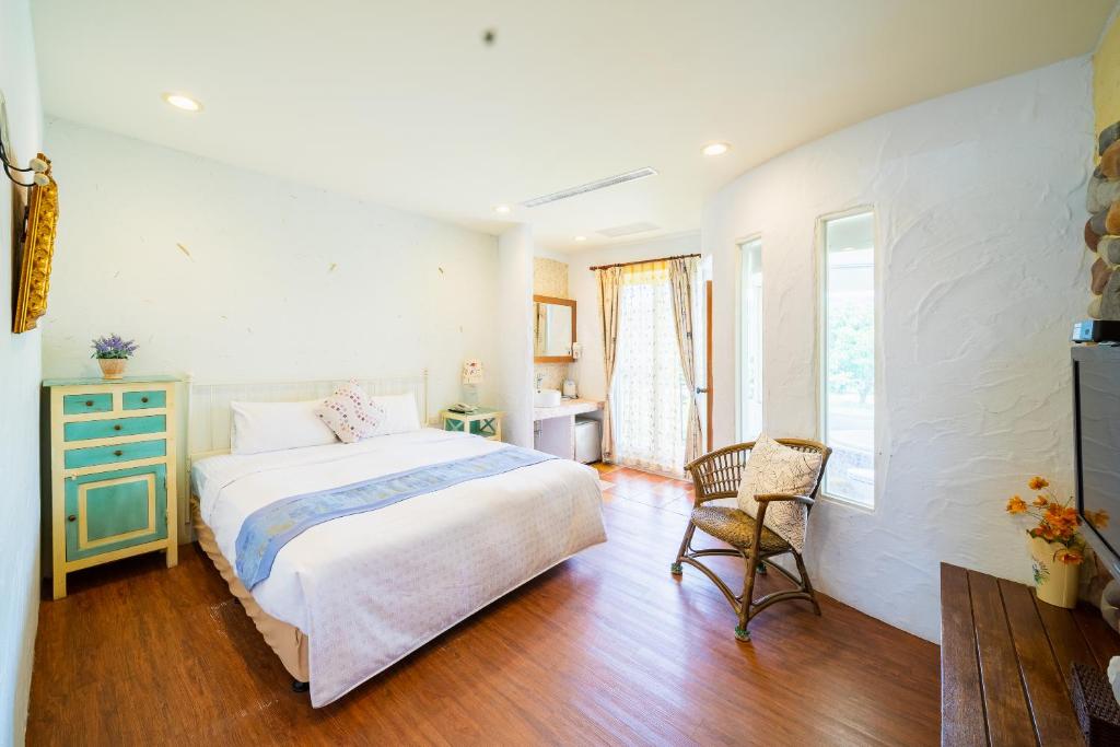 a bedroom with a bed and a chair in it at Mong Shan Homestay in Kenting