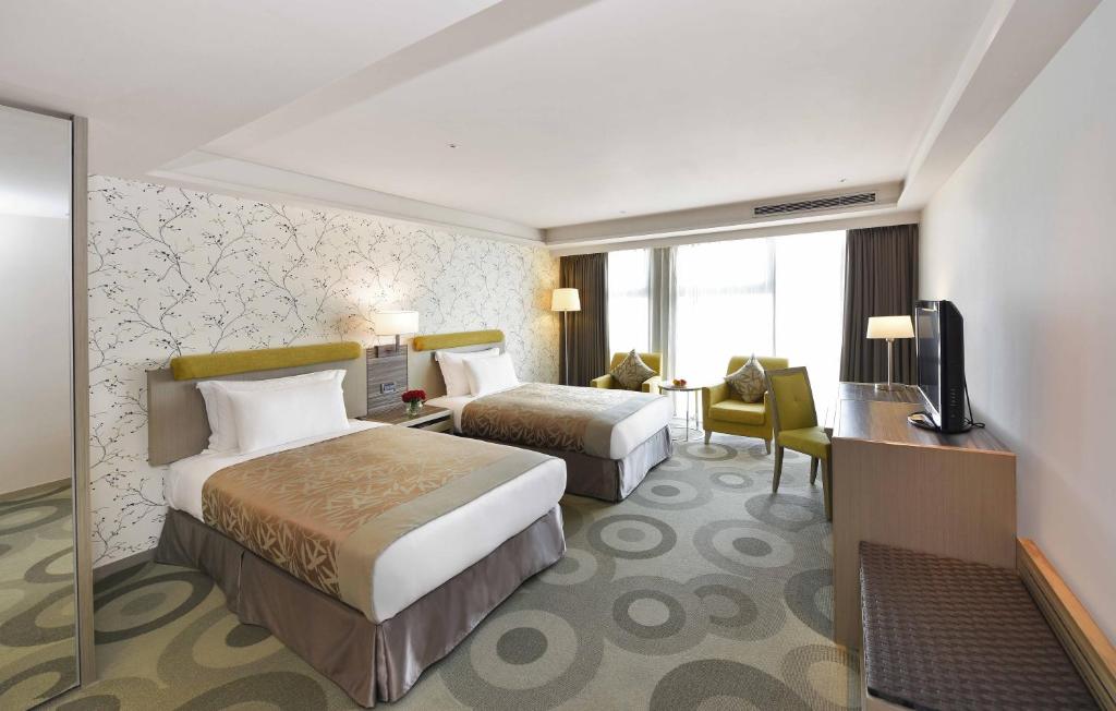 een hotelkamer met 2 bedden en een bureau bij Fullon Hotel Kaohsiung in Kaohsiung