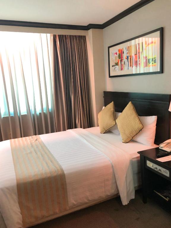 Postel nebo postele na pokoji v ubytování Tower Inn Makati Business Hotel
