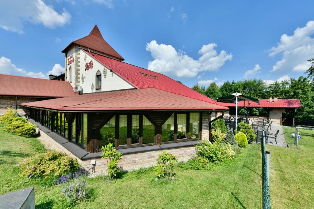 ein Gebäude mit einem roten Dach und einem Hof in der Unterkunft Wellness Hotel Fridrich in Horní Těrlicko