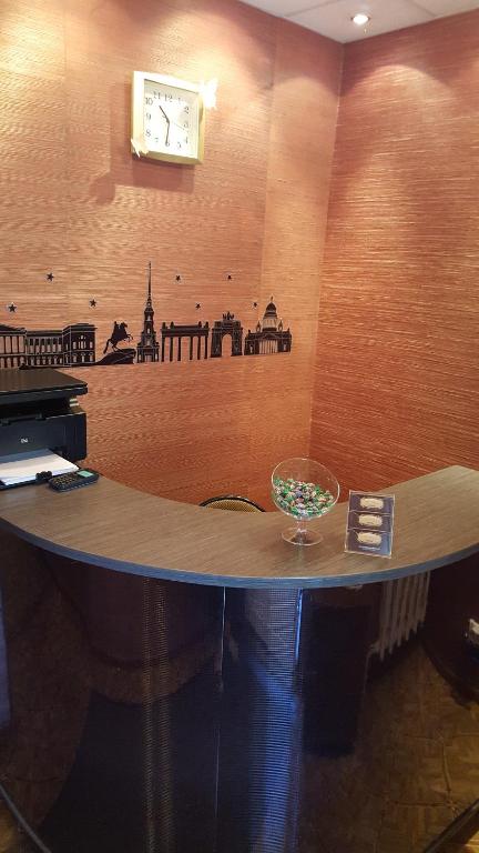 una mesa en una habitación con un reloj en la pared en Hotel Na Kuznechnoy, en Saratov