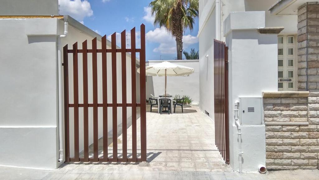 an open gate to a white house with an umbrella at Casa Vacanze Maria&Vito in Veglie