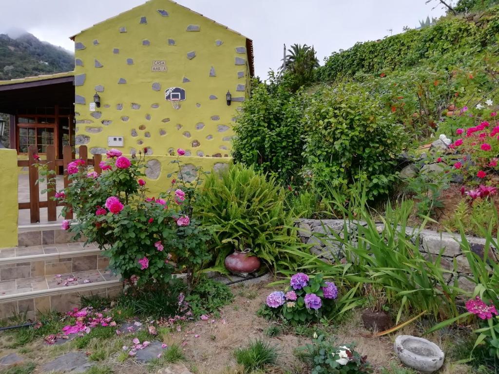 un edificio amarillo con flores en un jardín en Casa Maria en Agulo