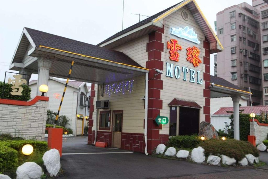 un motel con un cartel en la parte delantera en Sydney Motel en Tucheng