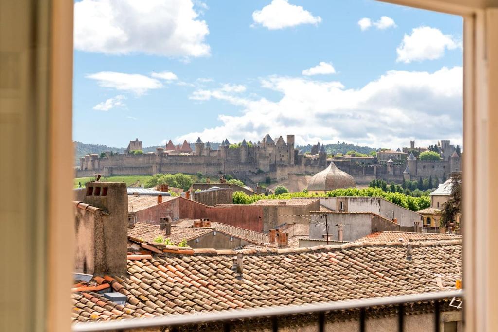 une vue d'une ville depuis une fenêtre dans l'établissement Les Clés de Laure - Wine Loft, Terrasse et Vue extraordinaire sur la cité médiévale, à Carcassonne