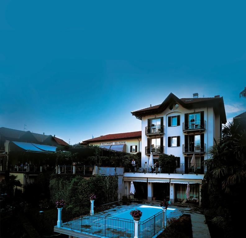 - un bâtiment avec une piscine en face dans l'établissement Hotel Belvedere Ranco, à Ranco