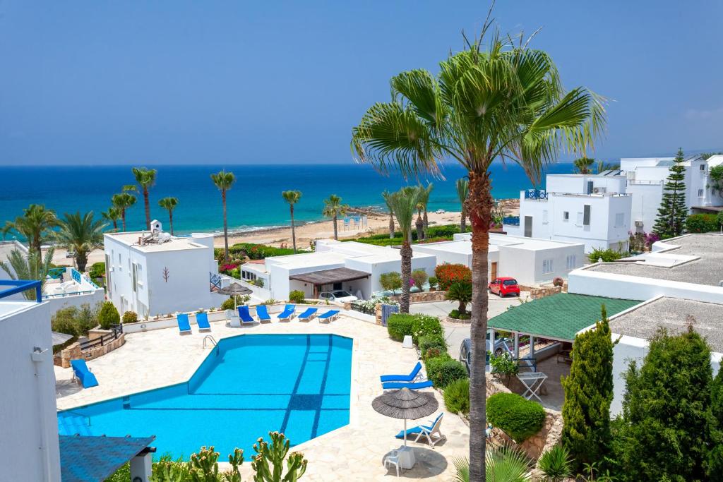 an aerial view of a resort with a swimming pool and the ocean at Villa Margo by the Sea in Paphos City