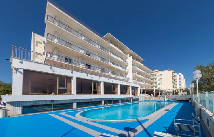 a swimming pool in front of a large building at Grand Hotel Excelsior in Senigallia