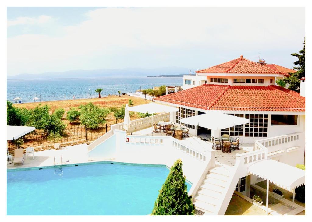 a large house with a swimming pool and a house with the ocean at Candia House in Kandia