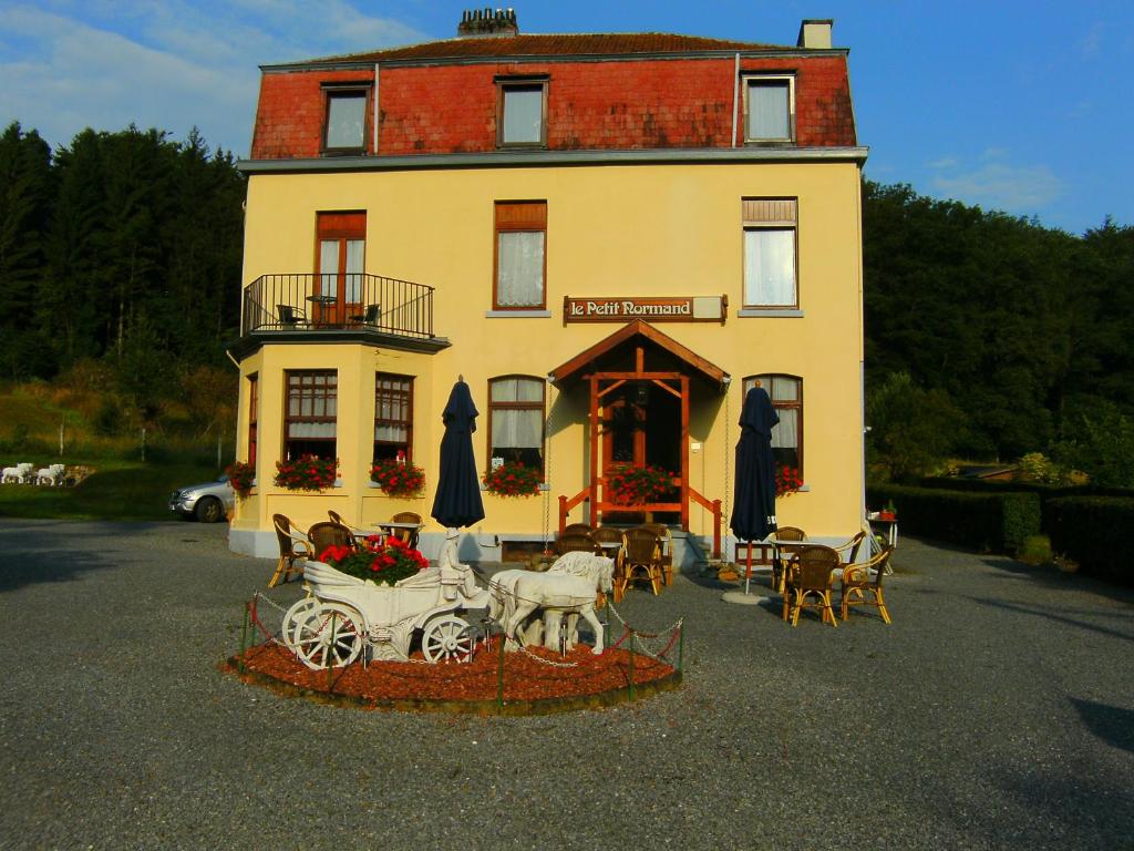 een gebouw met een paardenkoets ervoor bij B&B Le Petit Normand in Jalhay