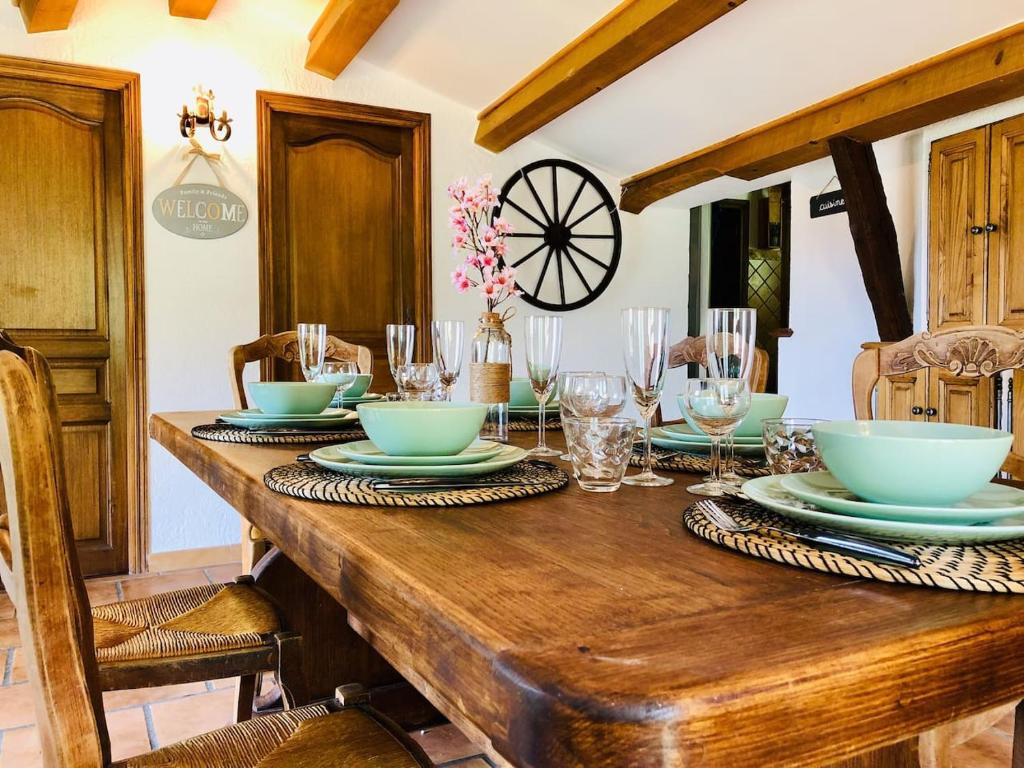 une table en bois avec des assiettes et des bols au-dessus dans l'établissement Maison de caractère Toudon - Arrière Pays Niçois - Proche Nice, à Toudon