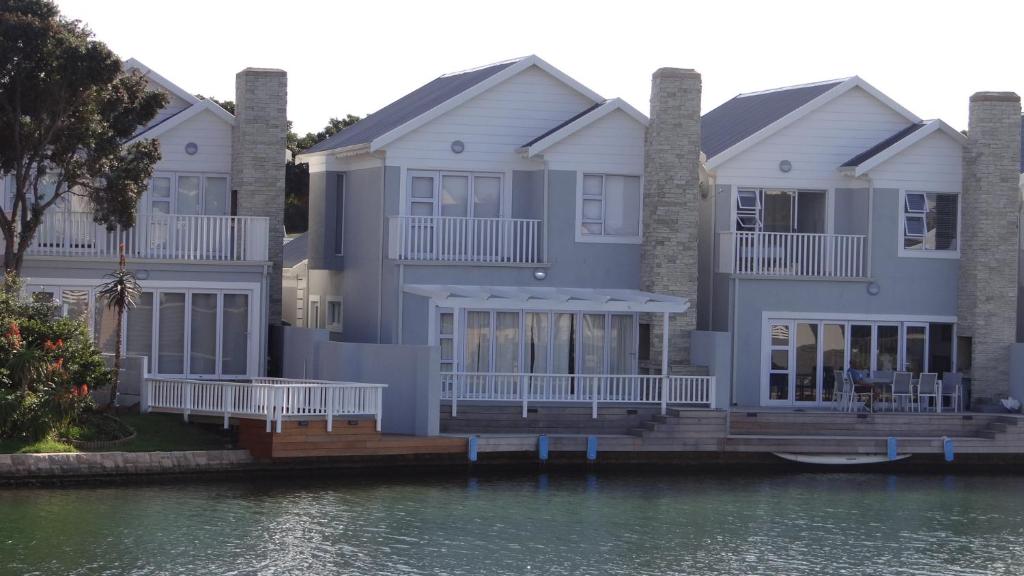 a large house on the water next to the water at Waterside Living CAN05 in Jeffreys Bay