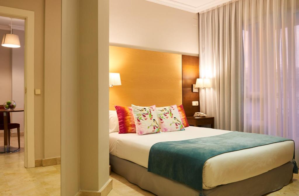 a hotel room with a bed with pillows at Suites Barrio de Salamanca in Madrid
