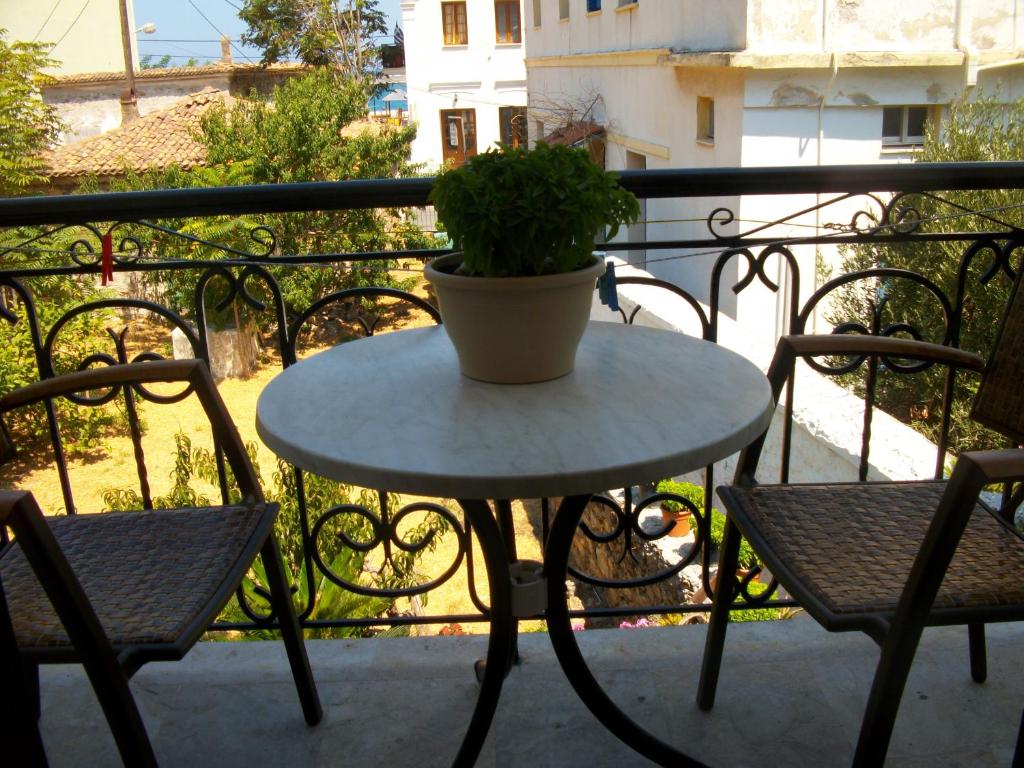 a table with a potted plant on a balcony at Jasmine's Guest House in Karlovasi