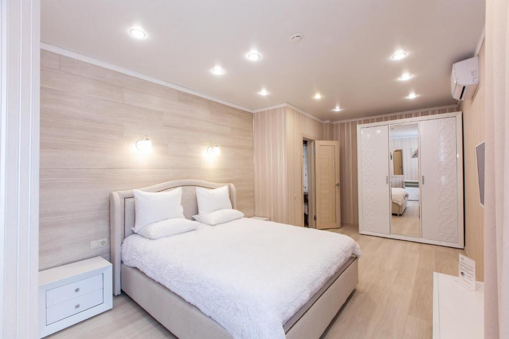 トムスクにあるSlobodaのベッドルーム(白いベッド1台、鏡付)