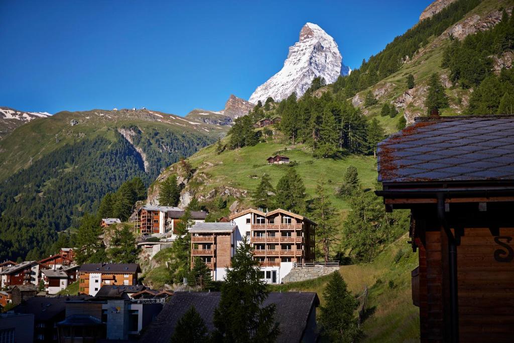 uma montanha à distância com uma cidade e edifícios em La Vue Luxury Living Apartments em Zermatt