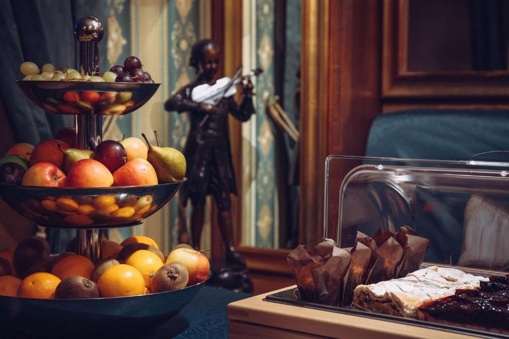 una mesa con dos cuencos de fruta y una estatua en Prague Old Street Apartments, en Praga