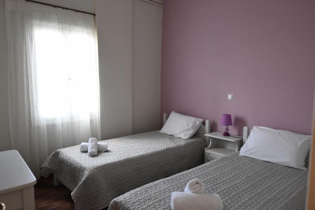 a small bedroom with two beds and a window at Rodi Retro in Nafplio