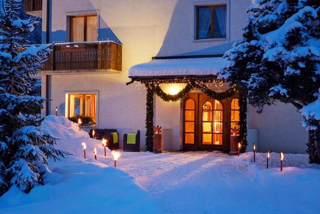 a house with christmas lights in the snow at Hotel Sonnwendhof Engelberg in Engelberg